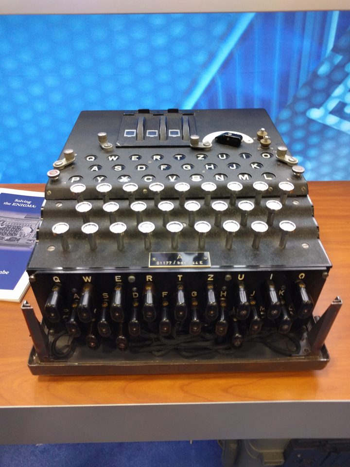 An Enigma machine with its keyboard, lampboard, plugboard and three rotor windows visible.